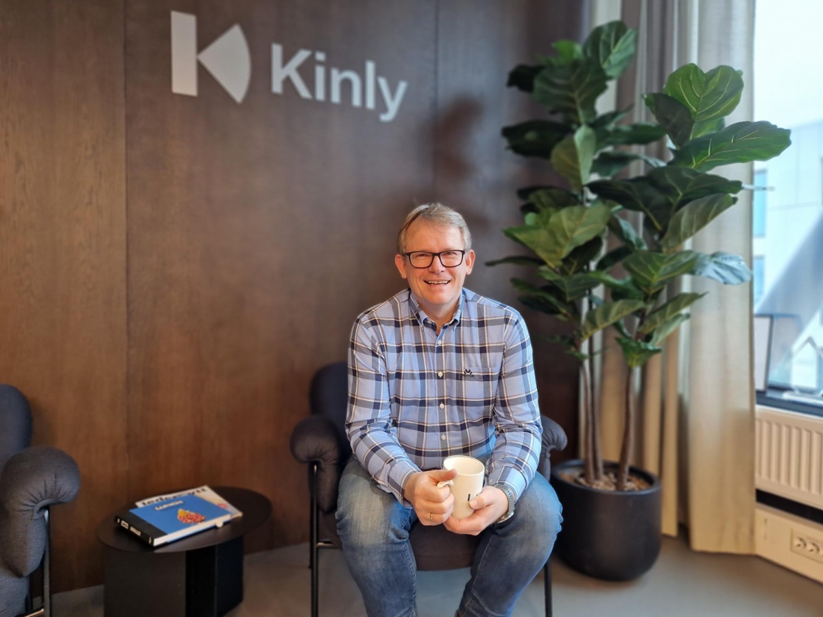 Morten fra support hos Kinly sitter på en stol med en kaffekopp i hånden