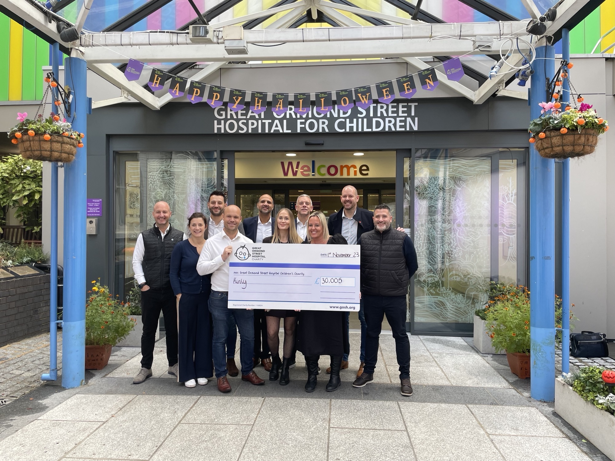 Kinly team present cheque at Great Ormond Street Hospital
